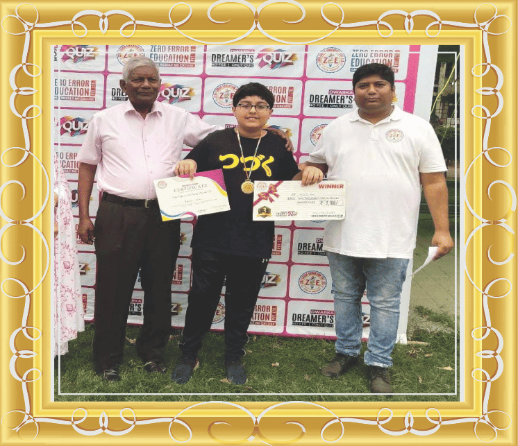Great—this is another award achievement photo featuring a winner holding a certificate and a ₹2,100 prize, with medals and a Zero Error Education backdrop.